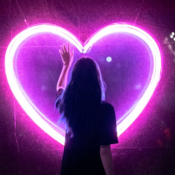 A compass with the needle pointing towards a glowing symbol of a heart and energy.