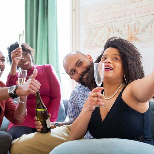 A diverse group of people smiling and looking energetic in a bright space.